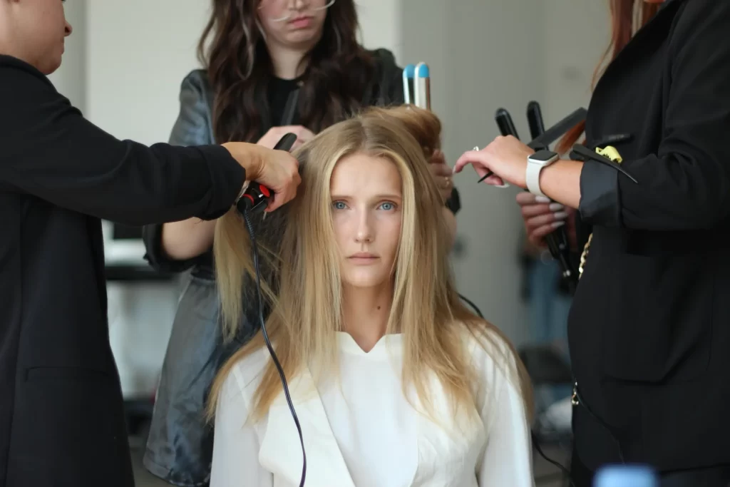 J. Joseph Salon stylists working on a model backstage