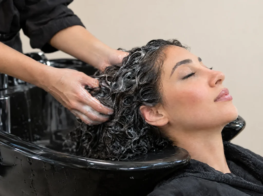 Conditioner worked through wet curls at the shampoo bowl